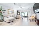 Bright living room features a large sectional sofa, stylish decor, and sliding glass doors to the lanai at 31408 Cabana Rye Ave, San Antonio, FL 33576