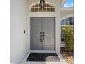 Close-up of the front door featuring a decorative window and tiled entryway at 4301 Ridgemoor N Dr, Palm Harbor, FL 34685