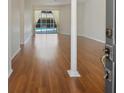 Bright, open living area showcasing laminate flooring and a view of the outdoor pool at 4301 Ridgemoor N Dr, Palm Harbor, FL 34685
