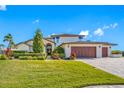 Charming two-story home featuring manicured landscaping, a paver driveway, and a three-car garage at 4803 Longwater Way, Tampa, FL 33615