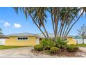 Charming home featuring palm trees and lush landscaping, enhancing its curb appeal at 512 173Rd E Ave, North Redington Beach, FL 33708