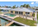 The rear exterior boasts an in-ground pool, seating area, and plenty of windows providing natural light at 512 173Rd E Ave, North Redington Beach, FL 33708