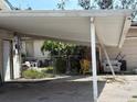 View of an outdoor carport with an adjacent shed and junk items on the lot at 5217 18Th S Ave, Gulfport, FL 33707