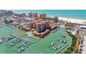 Breathtaking aerial view of a waterfront community with a marina, beach, and high-rise buildings at 525 Mandalay Ave # 33, Clearwater Beach, FL 33767