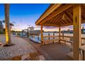 Charming waterfront setting featuring a private dock, boat lift, and a cozy gazebo overlooking the serene water at 5812 Mariners Watch Dr, Tampa, FL 33615