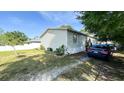 View of the single-story home featuring a well-maintained exterior, manicured landscaping, and convenient parking at 6051 106Th N Ave, Pinellas Park, FL 33782