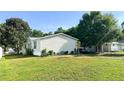 Side view of a charming one-story residence with well-kept lawn and ample greenery, complete with parking space at 6051 106Th N Ave, Pinellas Park, FL 33782