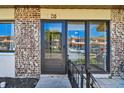 Inviting entryway with a brick accent wall, glass front door, and a cozy, secure, gated patio at 7360 Ulmerton Rd # 29B, Largo, FL 33771