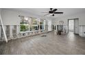 Bright, unfinished living room with new flooring, ceiling fan and large window at 810 Lantana Ave, Clearwater Beach, FL 33767