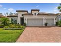 Charming home featuring a tile roof, brick driveway, and a well-manicured lawn at 8725 Sorano Villa Dr, Tampa, FL 33647