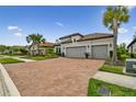 Charming home featuring a tile roof, brick driveway, and a well-manicured lawn at 8725 Sorano Villa Dr, Tampa, FL 33647