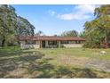 A charming single-story home with neutral brick, a spacious yard, and mature landscaping at 9825 Casey Dr, New Port Richey, FL 34654