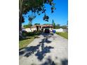 Exterior shot of home with a long driveway, well-maintained lawn, and a tidy storage shed at 1061 6Th Nw St, Largo, FL 33770
