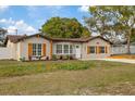 Charming home exterior with manicured lawn, complemented by natural wood shutters and accents at 11347 Amboy St, Spring Hill, FL 34609