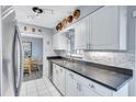 Well-lit kitchen showcasing a stainless steel sink, modern cabinets, and a stylish backsplash at 1496 Queen Anne Dr, Palm Harbor, FL 34684