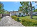 Charming single-story home featuring a well-maintained lawn, mature trees, and a concrete driveway at 1726 25Th S Ave, St Petersburg, FL 33712