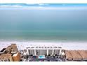 Stunning aerial view of beachside condos with a sparkling pool and pristine sandy beach at 18650 Gulf Blvd # 303, Indian Shores, FL 33785