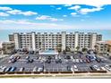 Aerial view of a beachfront condo building with a pool, parking, and stunning ocean views at 18650 Gulf Blvd # 303, Indian Shores, FL 33785