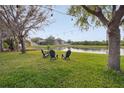 Scenic backyard with a pond view, string lights, and Adirondack chairs perfect for outdoor relaxation at 20224 Natures Spirit Dr, Tampa, FL 33647