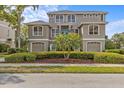 Charming two-story home with manicured bushes, a well-kept lawn, and a palm tree in the front yard at 2050 N Pointe Alexis Dr, Tarpon Springs, FL 34689