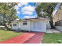 Charming home with brick driveway and manicured landscaping, offering a welcoming exterior at 2107 E 93Rd Ave, Tampa, FL 33612