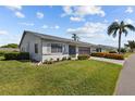 A single-story home featuring well-manicured lawns and landscaping, showcasing its curb appeal at 2411 Lancaster Dr, Sun City Center, FL 33573