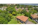 An aerial view displaying the home's roof, surrounding community, lush greenery, and water in the distance at 2934 Lichen Ln # A, Clearwater, FL 33760