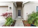 Inviting front entrance of a single-story home, accentuated by lush landscaping and a welcoming walkway at 30475 Satinleaf Run, Brooksville, FL 34602