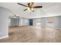 Bright living room with wood-look tile floors, ceiling fans, and a large blue front door at 3543 Rockaway Dr, Holiday, FL 34691