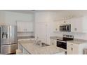 Modern kitchen features a spacious island, stainless steel appliances, and ample cabinetry at 35646 Eastbrook Ave, Zephyrhills, FL 33541