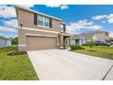 Two-story home with a two-car garage, a long drive and fresh landscaping at 36727 Spanish Rose Dr, Dade City, FL 33525