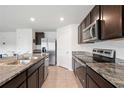 Kitchen with stainless steel appliances, granite counters, and tile flooring at 36727 Spanish Rose Dr, Dade City, FL 33525