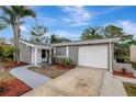 A well-maintained single-story home featuring a gray exterior with updated landscaping and a driveway at 4111 Stratfield Dr, New Port Richey, FL 34652