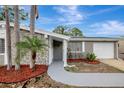 Inviting home entrance with a paved walkway, stone accents, and lush landscaping at 4111 Stratfield Dr, New Port Richey, FL 34652