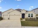 Charming one-story home with a two car garage, well-maintained lawn, and neutral stucco exterior at 6674 Cobble Bliss St, Zephyrhills, FL 33541