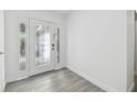 Bright entryway showcasing decorative glass front door and gray wood-look flooring at 706 Caliente Dr, Brandon, FL 33511