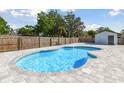 Backyard featuring a private swimming pool with brick coping, surrounded by a wood fence at 706 Caliente Dr, Brandon, FL 33511