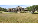 A well-manicured lawn leads up to this one-story stucco home with a stately entrance at 8403 Southwood Pines St, Lithia, FL 33547