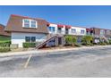 Condo building with stairwell access, red roofing, and nearby parking at 9105 W Hillsborough Ave # I102, Tampa, FL 33615