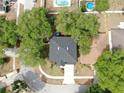 Aerial view of a home with a dark roof surrounded by lush, mature trees and neighboring homes at 934 Grand Canyon Dr, Valrico, FL 33594
