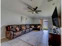 Relaxing living room featuring a comfortable leather sofa and large screen TV at 10222 Cool Waterlily Ave, Riverview, FL 33578