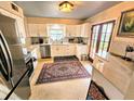 Modern kitchen featuring white cabinetry, stainless steel appliances, and granite countertops at 103 1St St, Belleair Beach, FL 33786