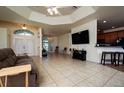 Bright living room featuring tiled floors, ceiling fan, and adjacent kitchen with breakfast bar at 10400 Golden Ave, Weeki Wachee, FL 34613