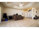 Bright living room with tiled floors, ceiling fan, and multiple entryways at 10400 Golden Ave, Weeki Wachee, FL 34613