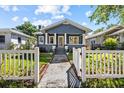 Charming blue home featuring a cozy front porch with a white picket fence at 1115 Crescent Lake N Dr, St Petersburg, FL 33701