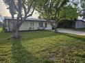 Landscaped front yard with mature trees providing shade and curb appeal at 1204 23Rd W Ave, Palmetto, FL 34221