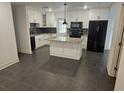 Modern kitchen with sleek black appliances, white cabinetry, and a central island at 1204 23Rd W Ave, Palmetto, FL 34221