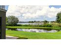 Scenic backyard view of a tranquil lake surrounded by lush greenery and reflections of the sky at 12170 Lake Allen Dr, Largo, FL 33773