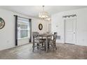 Cozy dining room with stylish chandelier, gray wood furniture, and natural lighting at 12618 Sandpine Reserve Pl, Gibsonton, FL 33534