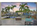 Backyard with palm trees, waterfront views, outdoor seating, and a cozy fire pit at 1361 46Th Ne Ave, St Petersburg, FL 33703
